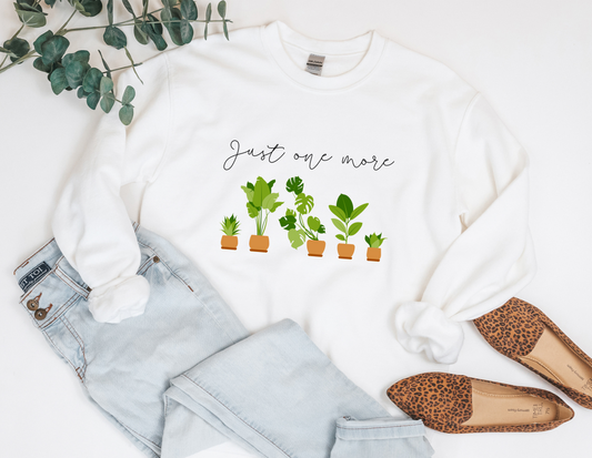 White crewneck sweatshirt featuring 5 house plants with the statement "just one more" written in sweeping hand lettered script