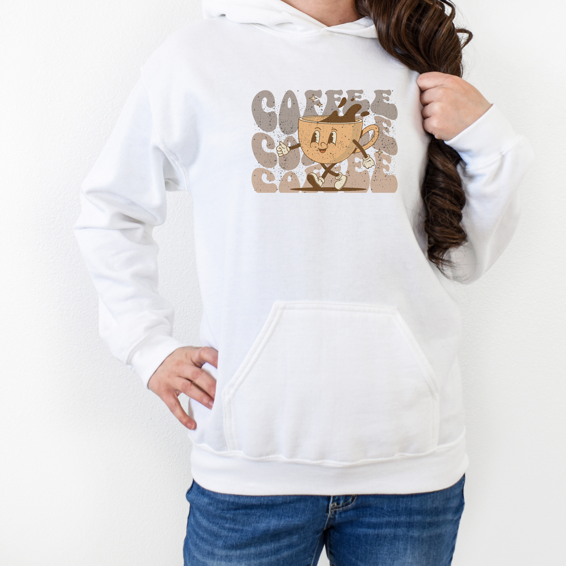 White hooded sweatshirt featuring a retro cartoon coffee cup walking with coffee written in bubble letters in the background 3 times in an ombre brown color